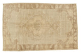 Vintage Turkish Oushak rug, subtle earth tones, faded central medallion, and soft charcoal-brown border.