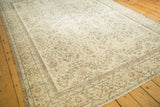 Faded botanical design with earth-tone outlines on the distressed pale ivory Oushak rug.