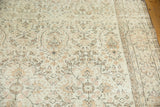 Distressed vintage Oushak carpet border, pale ivory field, and earth-tone outlines.