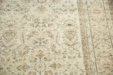 Distressed Oushak pile with faded rose and earth-tone botanical motifs on an ivory field.