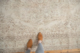 Faded vintage Oushak carpet detail, showing pale floral field and intricate traditional border.