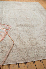 Faded floral patterns on blanched ivory field of vintage Oushak rug, subtle mint border.