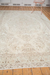 Blanched faded floral patterns and subtle mint green border on a vintage Oushak carpet.