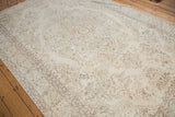 Blanched ivory Oushak carpet with faded floral medallion and subtle mint green border.