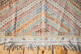 Fringed edge and colorful geometric border of the vintage Jajim rug with pastel diamond pattern.