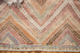 Textured, staggered knotting detail with soft pastel diamonds and blue striped lower edge of a Jajim rug.
