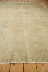 Distressed vintage Oushak carpet with faded beige and slate green surface texture.