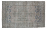 Vintage Oushak carpet with faded beige, grey, and slate blue side motifs, 5' x 8'1