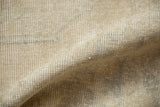 Vintage distressed Oushak rug pile with blanched beige and muted grey patterns.