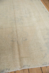 Distressed vintage Oushak rug with blanched tones and soft, faded pattern details.