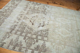 Distressed Oushak rug with faded beige and brown tone-on-tone traditional patterns.