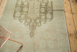 Soft tone-on-tone ivory and beige Oushak rug with subtle olive-green medallion detail.