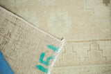 Hand-knotted Oushak rug's woven foundation with teal identifying markings and pale pile.