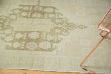 Soft, even pile and secured edge of a vintage Oushak rug with sea foam overcast.