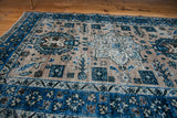 Distressed pile texture on a vintage Heriz rug with antique ivory and blue patterns.