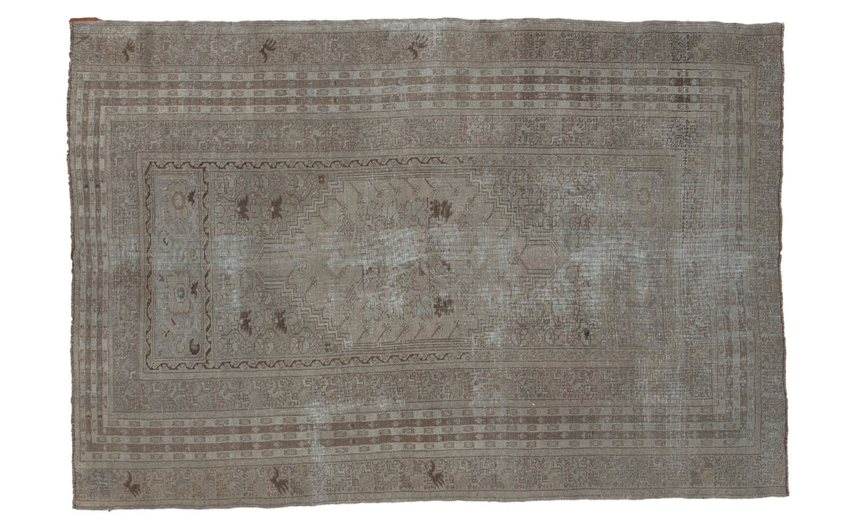 Distressed Kula rug, muted taupe tones, intricate borders, 4'6" x 6'8".