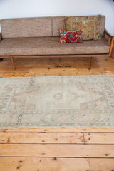 Vintage 1960s Turkish Oushak rug featuring a soft sandy beige field and faded medallion.
