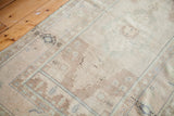 Hand-knotted vintage Turkish Oushak rug section in sandy beige with geometric border.