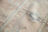 Textured pile of vintage Oushak rug showing sandy beige field with pale blue geometric motifs.