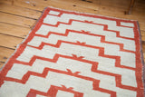 Simplistic stepped geometric pattern in textured cream and warm orange-red pile.