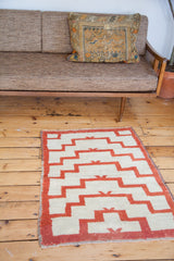 Stepped geometric pattern and shaggy Tulu pile in orange-red and off-white.