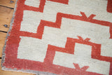 Stepped geometric pattern and shaggy texture of vintage Tulu rug in reddish-orange and cream.
