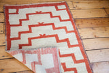 Folded corner of this Vintage Tulu rug, showing its reversible minimalist stepped pattern.