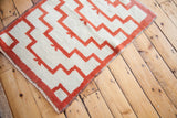 Vintage Tulu rug corner, orange stepped pattern on cream field, rustic fringe.