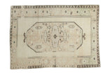 Blanched vintage Oushak carpet features faded ivory, beige, and charcoal geometric motifs, 6' x 8'4