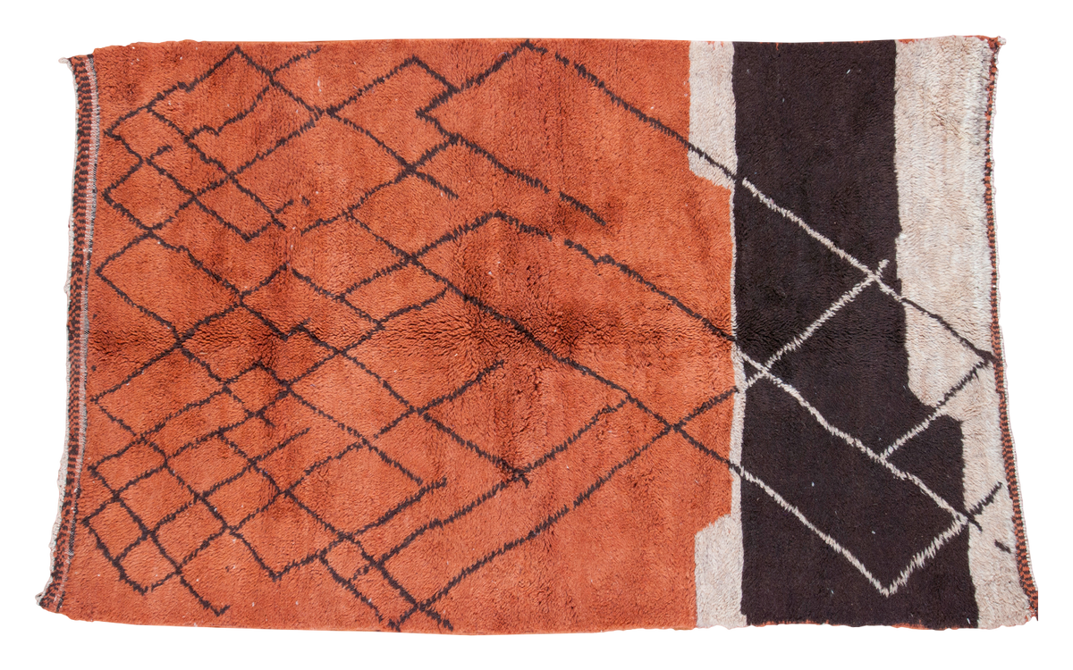 Vintage Moroccan rug, copper orange field with charcoal lattice motif, and ivory beige blocks.