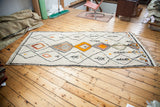 Vintage Moroccan runner features ivory ground, black geometric lattice, and vibrant diamond motifs.