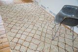 Moroccan rug with shaggy ivory pile and geometric apricot, grey accents.