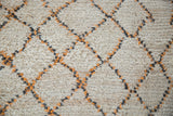 Shaggy ivory pile of vintage Moroccan rug with apricot and grey geometric diamond accents.