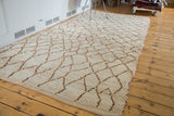 Shaggy texture of a vintage Moroccan rug with ivory, apricot, and grey diamond accents.