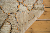 Vintage Moroccan runner's shaggy ivory pile contrasting its woven foundation with apricot and grey.