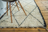 Pale ivory shaggy pile and sharp black geometric lattice pattern on vintage Moroccan rug.