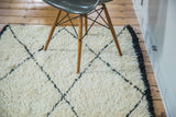 Shaggy ivory pile of this vintage runner, featuring sharp black lattice diamond pattern and dark fringe.