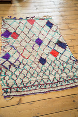 Vibrant geometric patterns in hot red, purple, and green on this shaggy Moroccan rug.