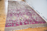 Textured eggplant Moroccan rug pile with multi-medallion pattern and worn fringe.
