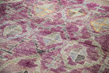 Shaggy pile texture of vintage Moroccan rug with eggplant purple, grey, and charcoal medallions.