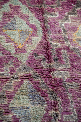 Thick pile detail of a vintage Moroccan rug with eggplant purple and grey geometric patterns.