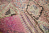 Plush, geometrically patterned eggplant purple pile with striped woven back of the Moroccan rug.