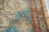 Geometric reddish-brown animal motif on aqua blue, with a patterned Anatolian border.