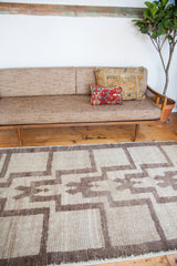 Vintage Tulu rug's textured pile, displaying stepped germinating plant motifs in silver and grey.