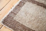 Textural close-up of vintage Tulu rug's shaggy pile, revealing stepped cream and brown design.