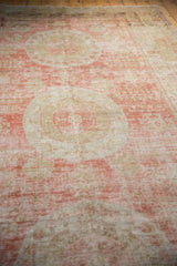 Angled view of an antique Khotan carpet's distressed low pile with soft red and charcoal abrash.