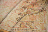 Distressed low-pile weave of an antique Khotan carpet in soft ivory, beige, and faded red.