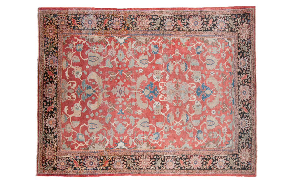 Antique Sultanabad carpet: brick red field, sprawling floral pattern, blues, earth tones.