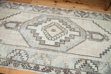 Intricate geometric stepped medallion in platinum, faded celadon, and ivory of the vintage Oushak.