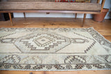 Geometric border patterns and fringe at the corner of a vintage Oushak rug.